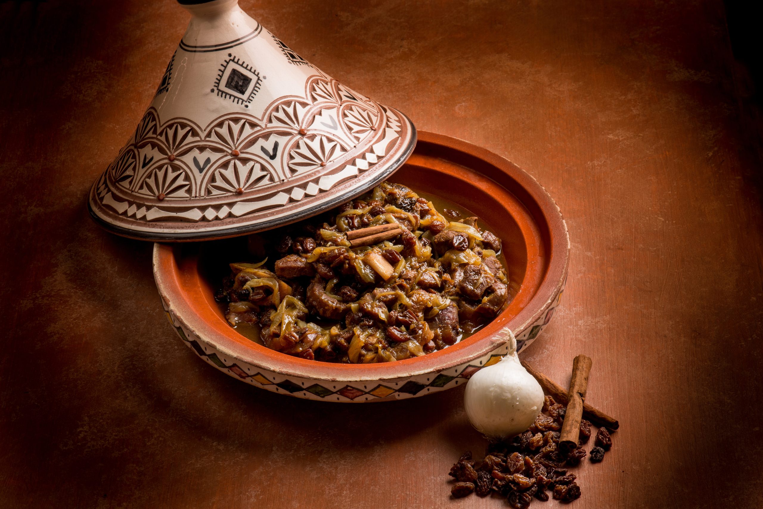 tajine with meat, onion, dried grape and cinnamon